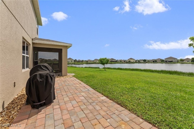 view of yard featuring a water view and a patio