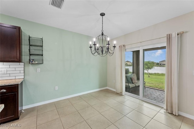 unfurnished dining area featuring a notable chandelier and light tile patterned flooring