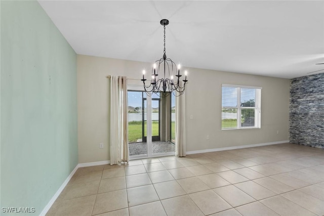 empty room with light tile patterned floors and a chandelier