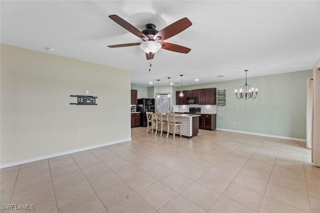 kitchen featuring a center island, hanging light fixtures, backsplash, black appliances, and ceiling fan with notable chandelier