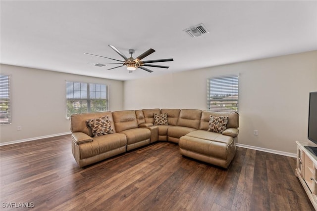 living room featuring dark hardwood / wood-style flooring, a wealth of natural light, and ceiling fan