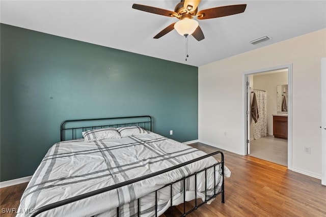 bedroom featuring connected bathroom, hardwood / wood-style flooring, and ceiling fan