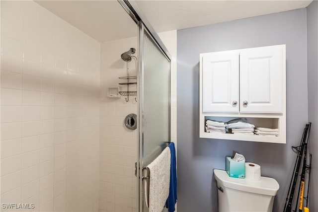 bathroom with toilet and a shower with shower door