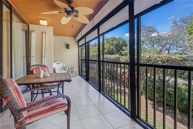 sunroom featuring ceiling fan, a healthy amount of sunlight, and wooden ceiling