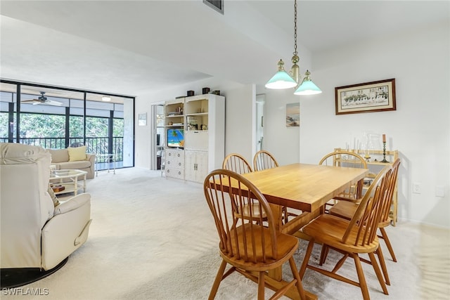 dining space with ceiling fan, light colored carpet, visible vents, baseboards, and floor to ceiling windows