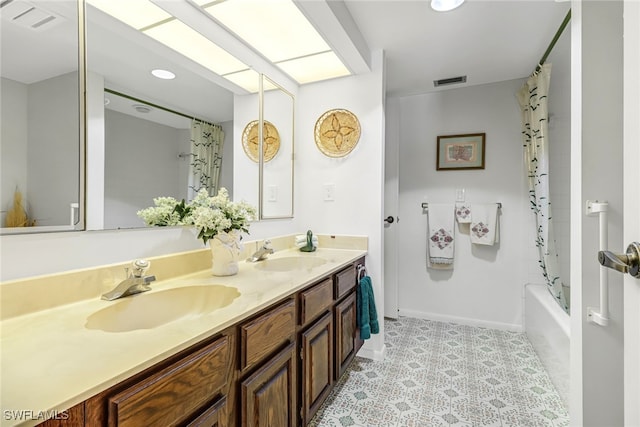 bathroom featuring double vanity, visible vents, and a sink