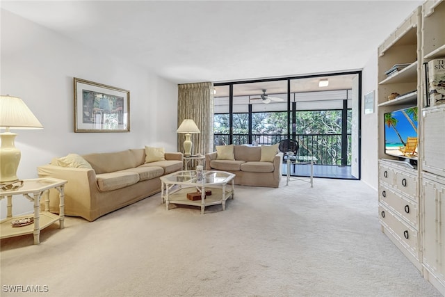 living room featuring ceiling fan, a wall of windows, and light carpet