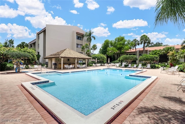 community pool featuring a gazebo, a patio area, and fence