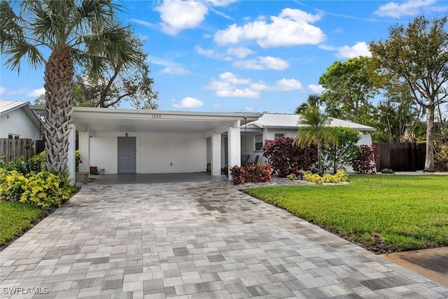 ranch-style home featuring a carport and a front yard