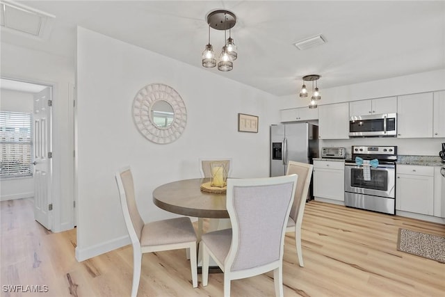 dining room with a notable chandelier and light wood-type flooring