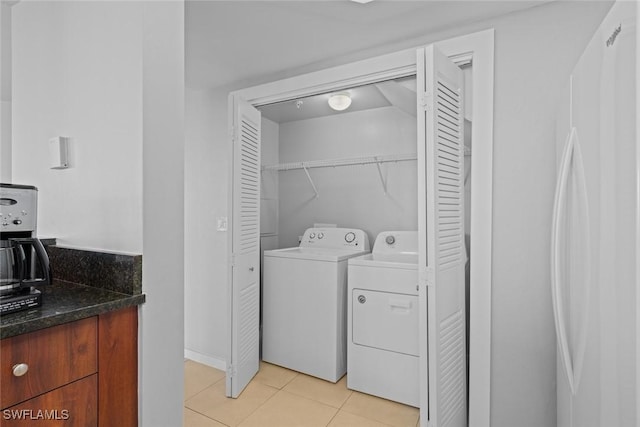 clothes washing area featuring washer and dryer and light tile patterned floors