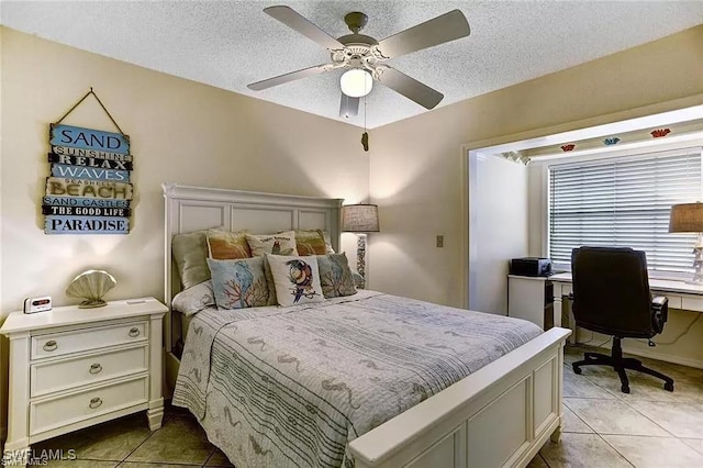 bedroom with tile patterned floors, ceiling fan, and a textured ceiling