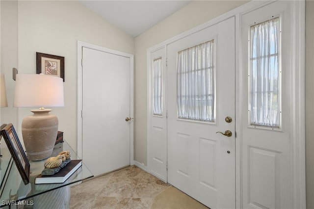 entrance foyer featuring a healthy amount of sunlight and vaulted ceiling