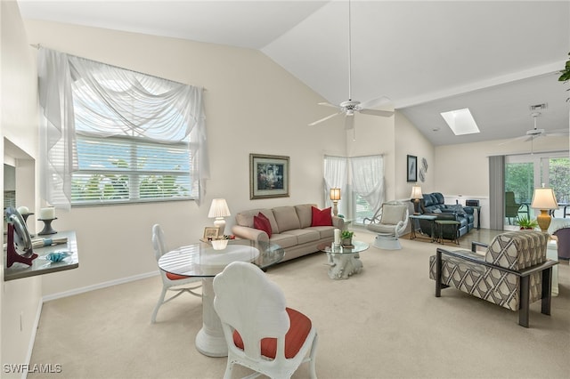 living room featuring light carpet, lofted ceiling with skylight, and ceiling fan