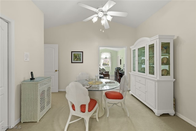 dining area featuring ceiling fan, light carpet, and vaulted ceiling