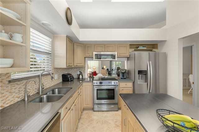 kitchen featuring light brown cabinetry, a healthy amount of sunlight, sink, and stainless steel appliances