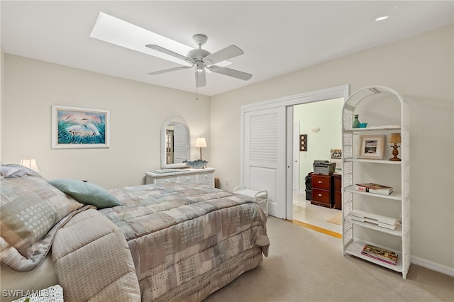 bedroom featuring ceiling fan, a closet, and light colored carpet