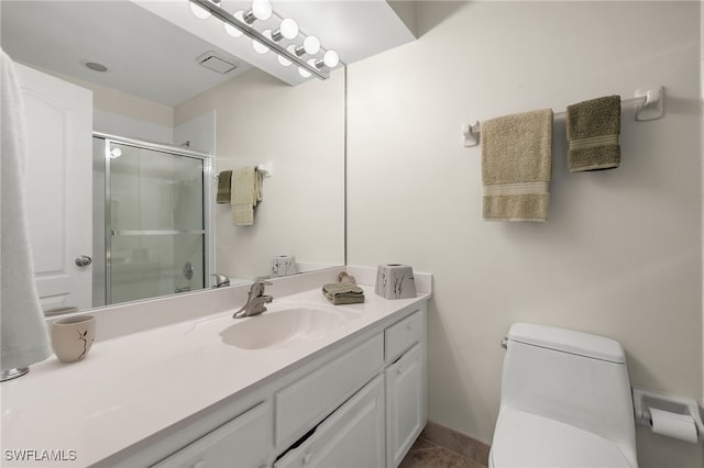 bathroom with tile patterned floors, a shower with door, vanity, and toilet