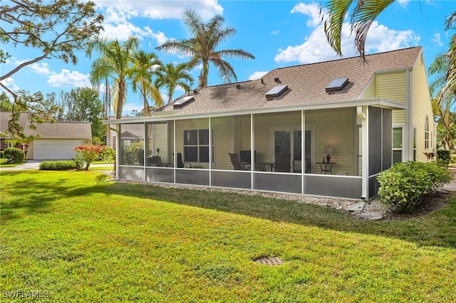 back of house featuring a lawn and a sunroom