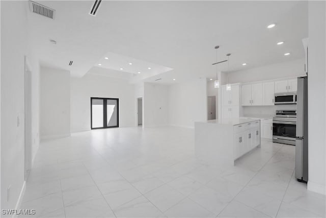 kitchen featuring white cabinetry, a center island, pendant lighting, and appliances with stainless steel finishes