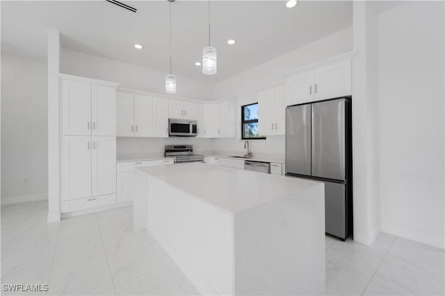 kitchen featuring pendant lighting, a center island, white cabinets, sink, and stainless steel appliances