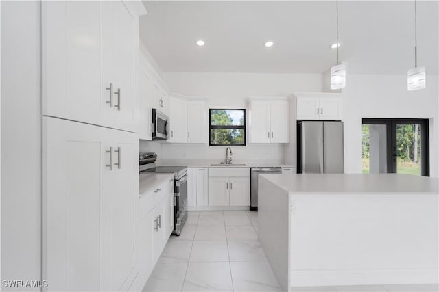 kitchen featuring white cabinets, hanging light fixtures, sink, and appliances with stainless steel finishes