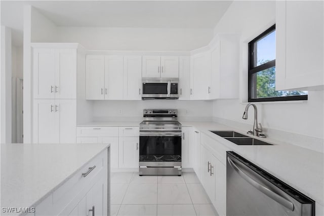 kitchen featuring light tile patterned flooring, sink, white cabinetry, and stainless steel appliances