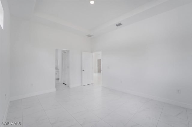 unfurnished room featuring a towering ceiling and a tray ceiling