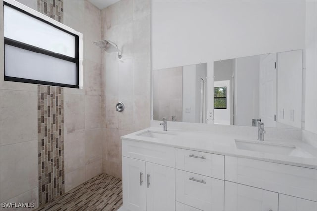 bathroom with tiled shower and vanity