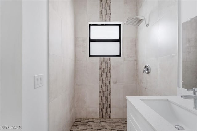 bathroom featuring a tile shower and sink