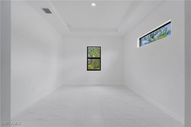 unfurnished room with a raised ceiling