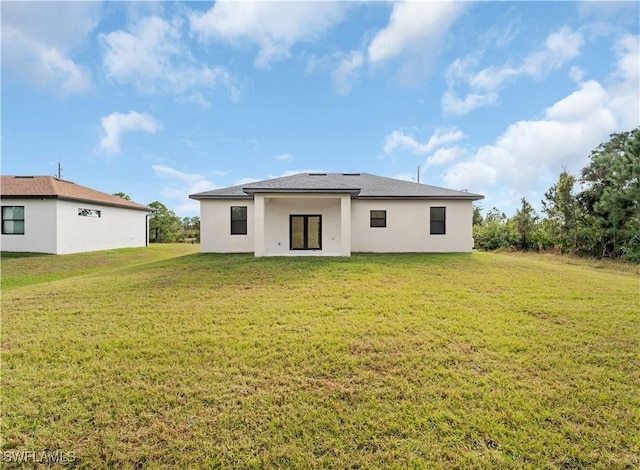 rear view of property with a lawn