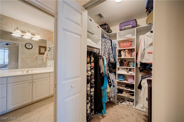 walk in closet featuring sink and light tile patterned floors