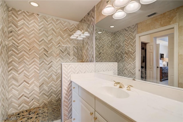 bathroom with vanity, walk in shower, and tile walls