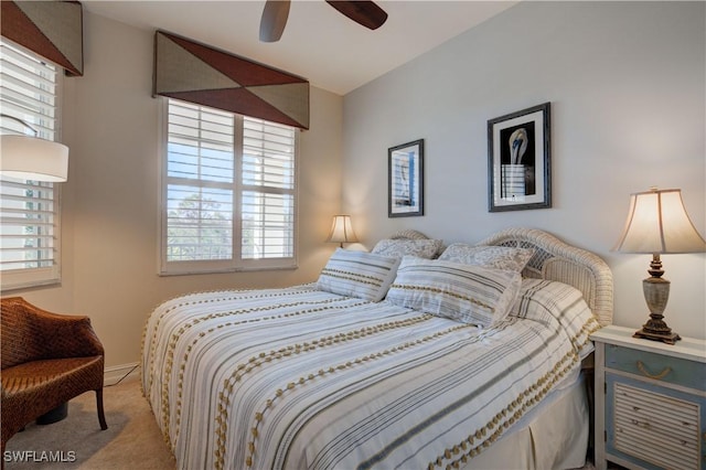 bedroom with ceiling fan, light colored carpet, and multiple windows