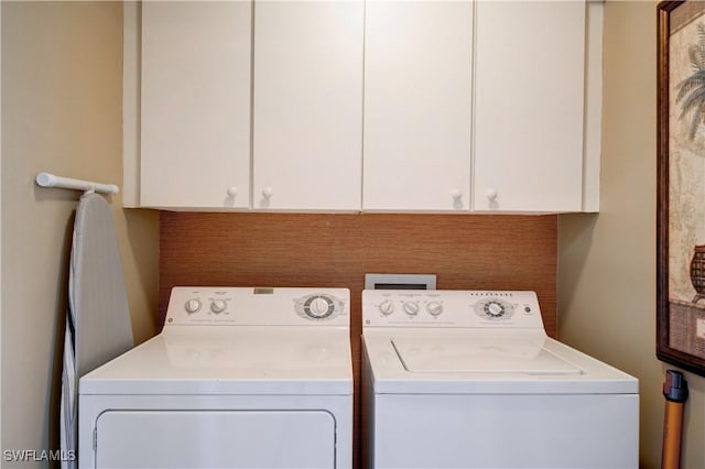 laundry room with washing machine and dryer and cabinets