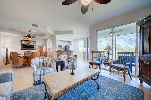 living room with ceiling fan with notable chandelier and light tile patterned flooring