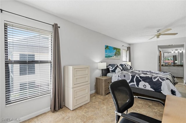 bedroom featuring a textured ceiling, connected bathroom, a ceiling fan, and baseboards