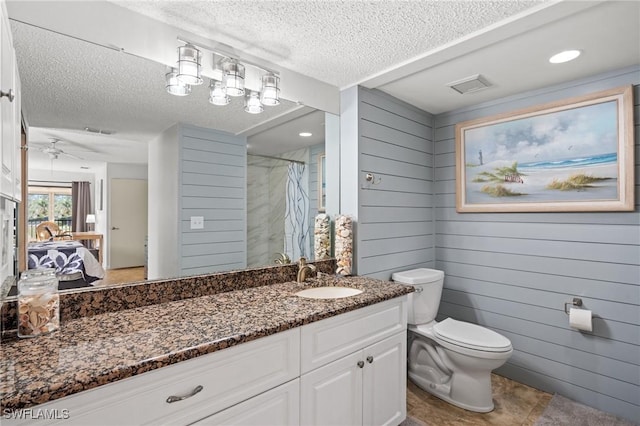 bathroom with ceiling fan, a textured ceiling, toilet, wooden walls, and a shower with shower curtain