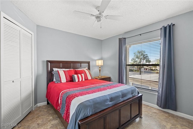 bedroom with a textured ceiling, a closet, a ceiling fan, and baseboards