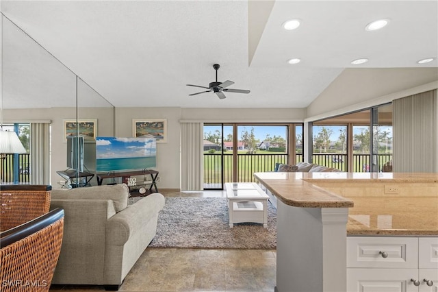 living room with ceiling fan, lofted ceiling, and a wealth of natural light