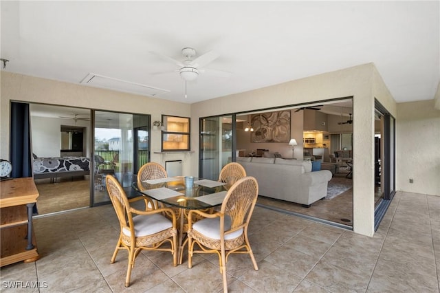 dining area featuring light tile patterned floors, ceiling fan, and attic access