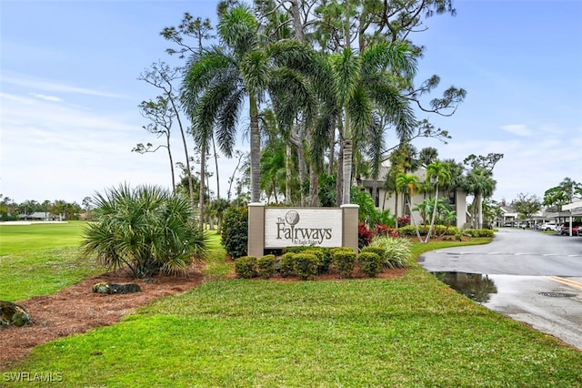 community sign with driveway and a yard