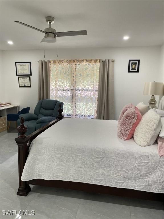 tiled bedroom featuring ceiling fan