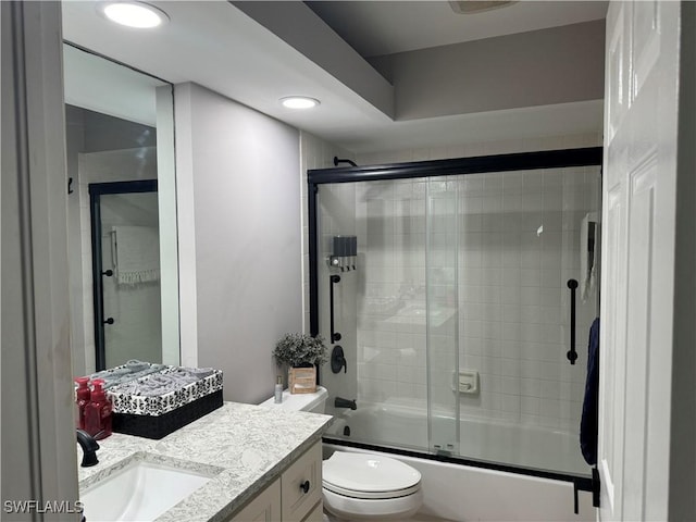 full bathroom featuring shower / bath combination with glass door, vanity, and toilet