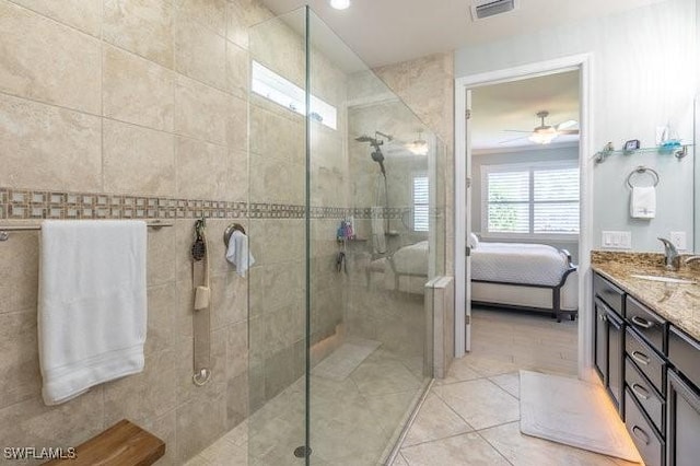 bathroom featuring tile patterned floors, ceiling fan, a shower with shower door, and vanity