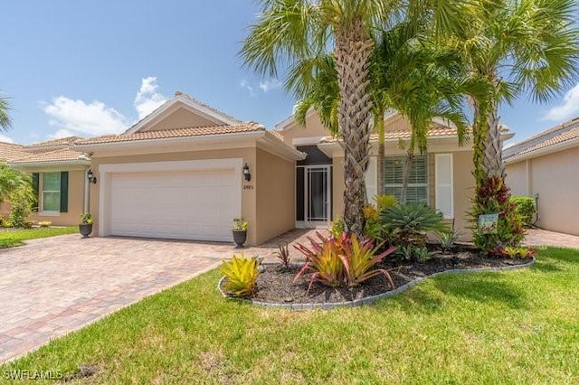 mediterranean / spanish-style home featuring a garage and a front yard