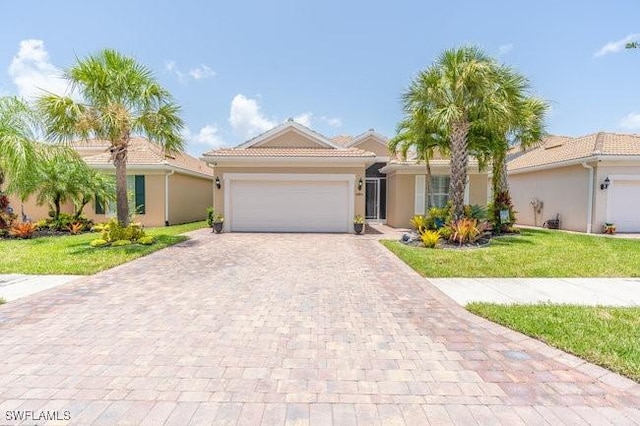 mediterranean / spanish house with a front lawn and a garage