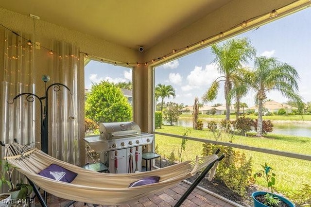 sunroom featuring a water view