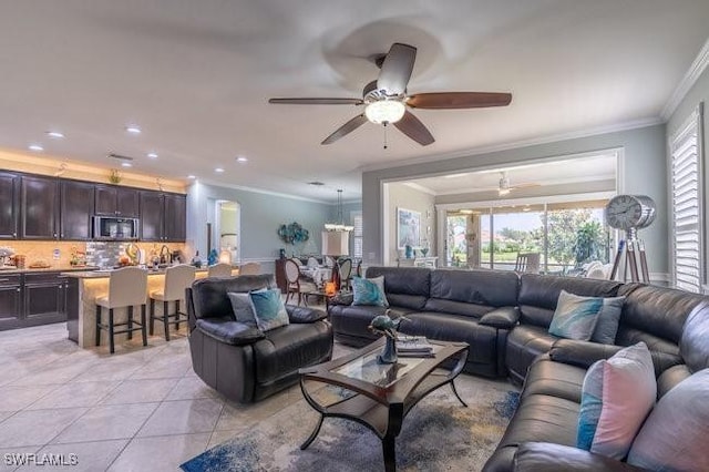 tiled living room with ceiling fan and crown molding